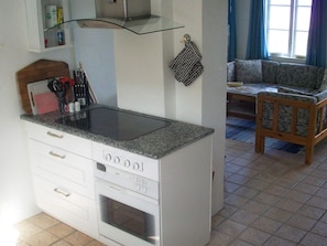 A compact kitchen with a built-in stove, oven, and a small countertop. - 6 Person Holiday Home in Aabenraa (Aabenraa)