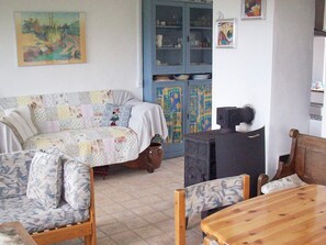 A living room with a sofa, chairs, a wooden table, a cabinet with glass doors, and a television. - 6 Person Holiday Home in Aabenraa (Aabenraa)