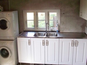 A laundry area with a washing machine, a sink, and cabinets. - 6 Person Holiday Home in Aabenraa (Aabenraa)