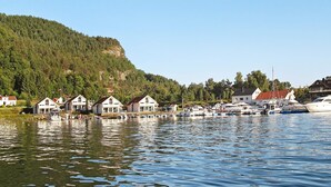 A lakeside village with houses along the shore and boats docked in the water. - 5 Star Holiday Home in Jelsa (Suldal)