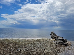 Un rivage rocheux offrant une vue dégagée sur la mer et le ciel.