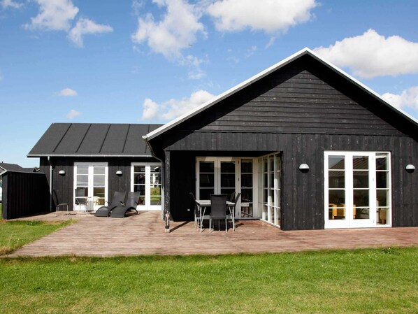 A black building with a sloped roof and large windows.