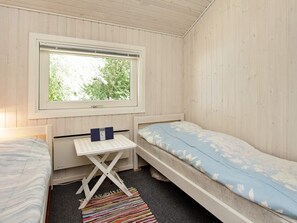 Ett litet, enkelt rum med en säng, ett skrivbord och ett fönster.