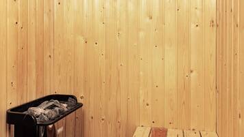 Una stanza sauna con parete in legno, una panchina e uno scaldabagno.