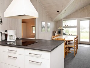 A modern kitchen with a built-in island, white cabinetry, and a coffee maker.