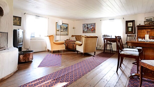 A living room with wooden flooring, a fireplace, a television, and a dining area with chairs and a table. - 5 Person Holiday Home in Jonkoping (Jonkoping)