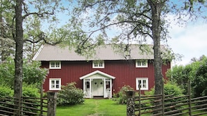 A red building with a white porch and a small garden in front. - 5 Person Holiday Home in Jonkoping (Jonkoping)