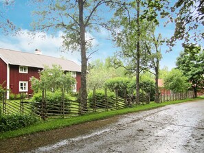 A rural road with a red barn and wooden fences. - 5 Person Holiday Home in Jonkoping (Jonkoping)