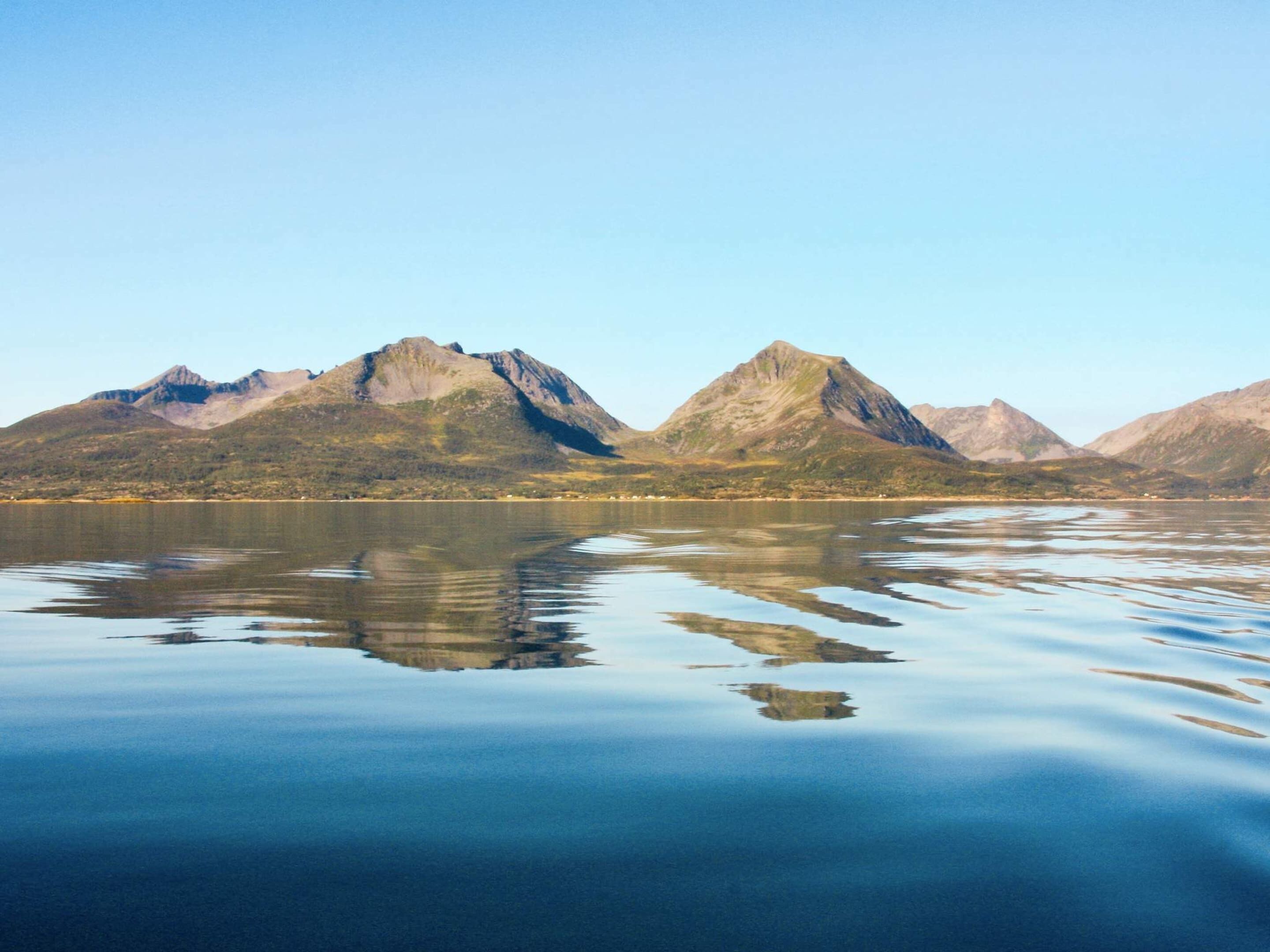 A calm lake with mountains in the background.
