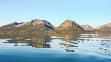 A calm lake with mountains in the background.