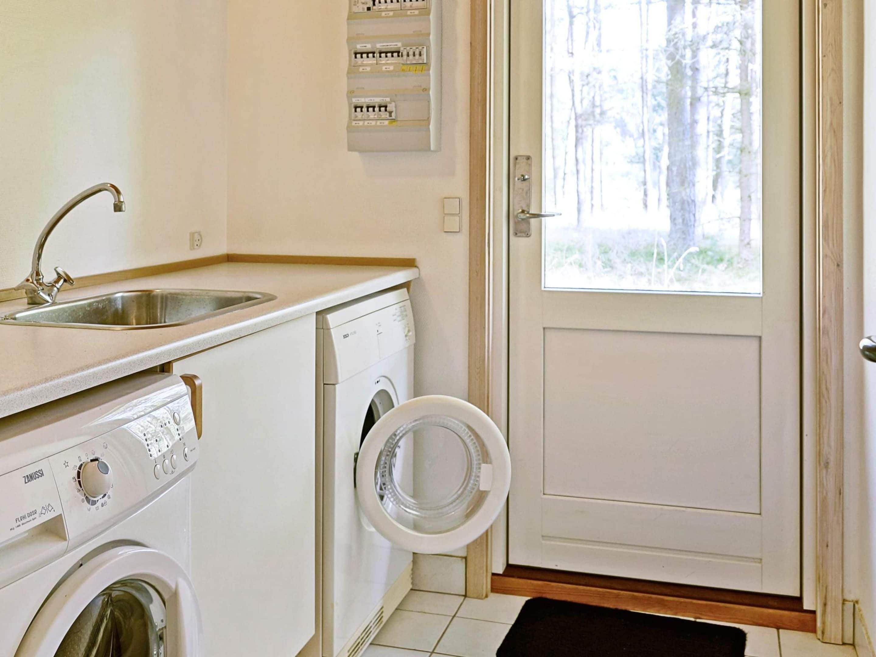 A laundry room with a washing machine, dryer, and a sink.