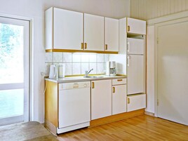 A kitchen with white cabinets, a coffee maker, and a sink.