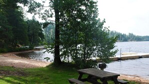 Ein Picknicktisch am Seeufer mit einem Steg, der ins Wasser führt.