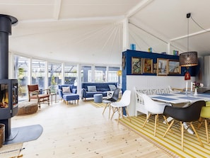 A spacious living area with a fireplace, seating, and a dining table. - 8 Person Holiday Home in Tranekaer (Tranekaer)
