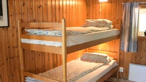 A bunk bed room with wooden walls and a small window. - 4 Person Holiday Home in Torsby (Torsby)