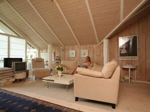 A cozy living room with a sofa, a coffee table, and a television. - 4 Star Holiday Home in Dronningmolle (Dronningmolle)