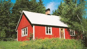 A red wooden house with a white roof, surrounded by trees and greenery. - 6 Person Holiday Home in Osby (Osby)