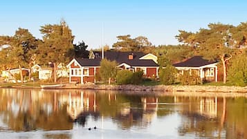 A residential area with houses along a calm lake, a dock, and a clear sky.