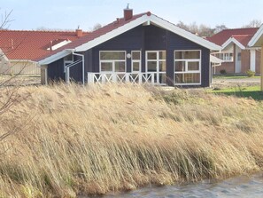Een huis met een puntgevel en een witte veranda.