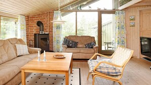 A cozy living room with a brick fireplace, wooden ceiling, and large windows. - 8 Person Holiday Home in Fjerritslev-by Traum (Fjerritslev)