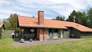 A brick house with a red roof, a chimney, and a covered patio area with outdoor furniture. - 8 Person Holiday Home in Fjerritslev-by Traum (Fjerritslev)