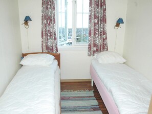 A room with two single beds, a window with curtains, and two wall-mounted lamps. - 4 Person Holiday Home in Lauvstad (Volda)