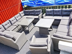 A sectional sofa with attached side tables, arranged on a gravel patio. - Holiday Home in Mellerud (Mellerud)