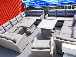 A sectional sofa with attached side tables, arranged on a gravel patio. - Holiday Home in Mellerud (Mellerud)