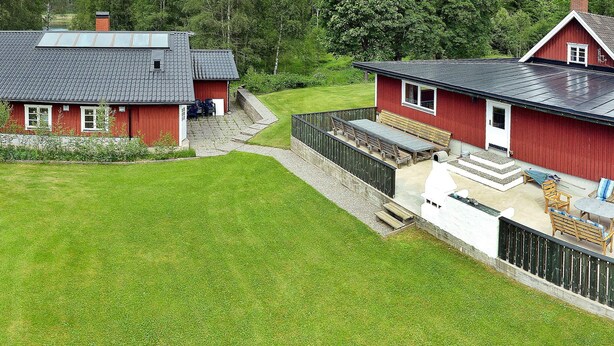 A red house with a sloped roof and a covered patio area.