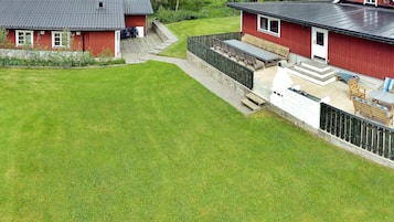 Ett rött hus med ett sluttande tak och en täckt uteplats.