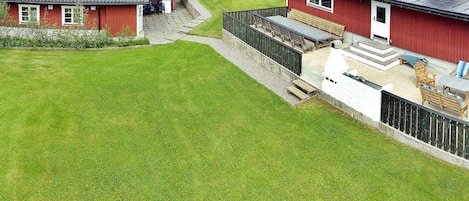 A red house with a sloped roof and a covered patio area.