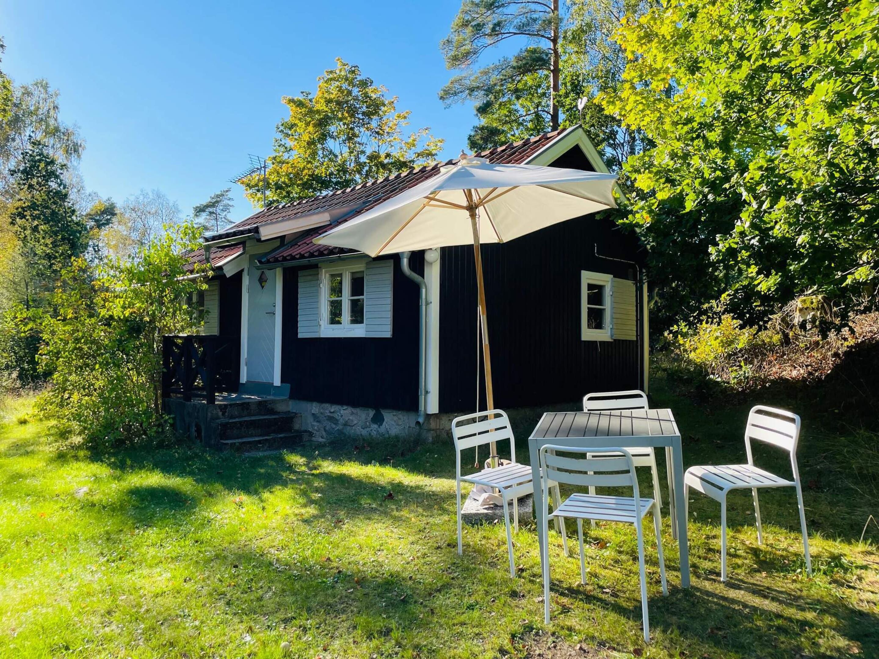 A small house with a porch and a table with chairs.