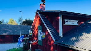 En rød bygning med et skilt for 'Wildmarks-café' og et blåt flag med et logo.