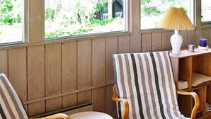 Two striped armchairs with wooden frames and white cushions, positioned next to a small white table.