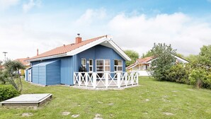 A blue house with a white porch and a red roof. - Holiday Home in Otterndorf (Otterndorf)