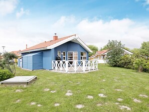 A blue house with a white porch and a red roof. - Holiday Home in Otterndorf (Otterndorf)
