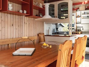 A wooden dining table with chairs, a laptop, and a decorative item. - 4 Star Holiday Home in Hurup Thy (Hurup Thy)