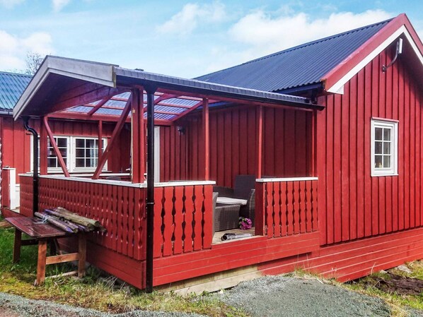 A red wooden house with a porch, a window, and a bench. - 4 Star Holiday Home in Storfosna (Orland)