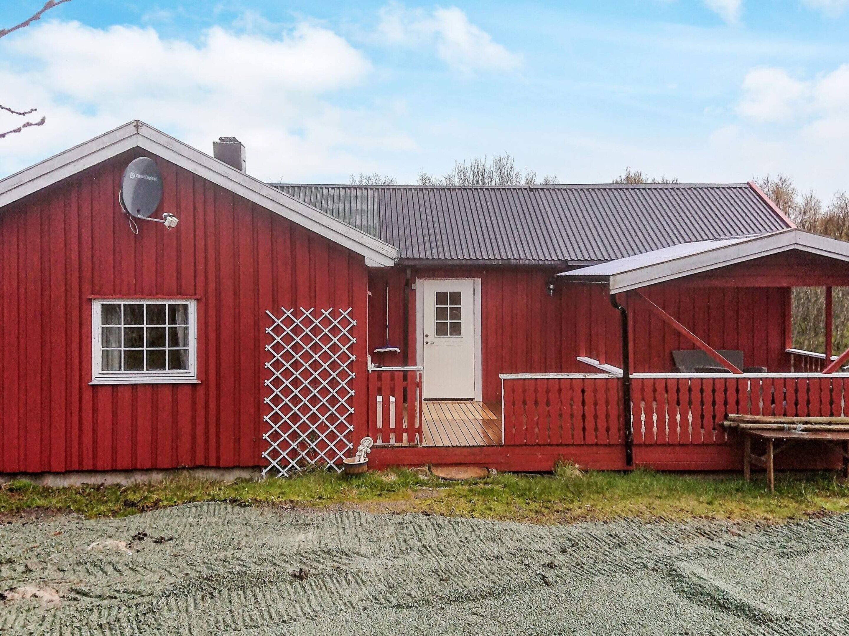 A red barn with a white door, a window, and a lattice door.