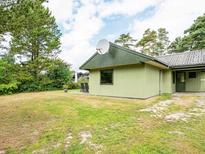 A single-story building with a satellite dish, a front door, and a small porch area.