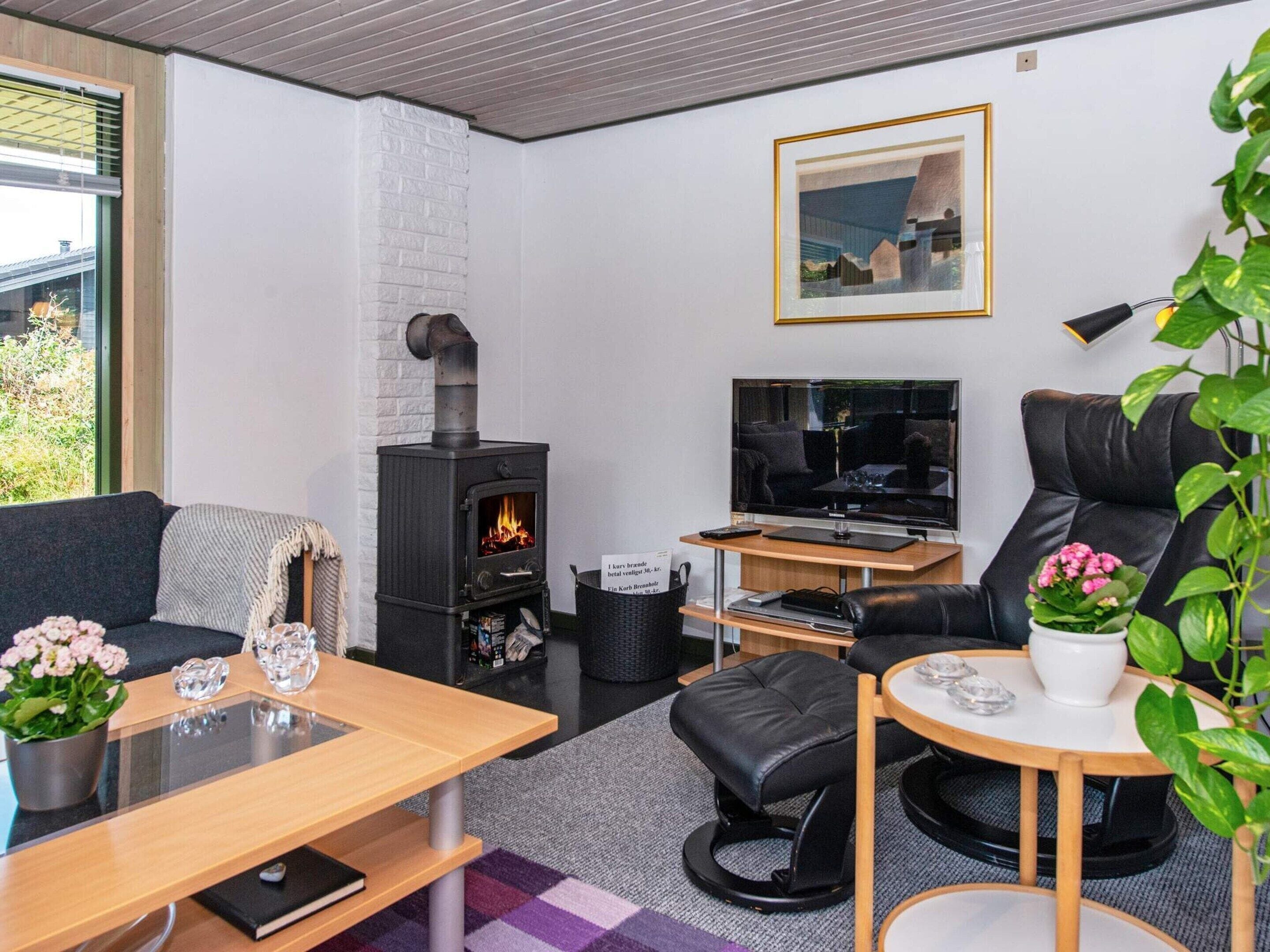 Una sala de estar moderna con chimenea, un sofá, una mesa de centro y un televisor.