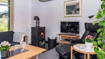 Una sala de estar moderna con chimenea, un sofá, una mesa de centro y un televisor.