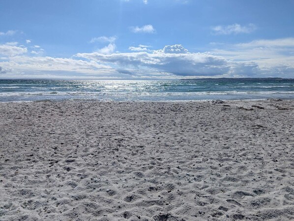 En strand med klar himmel och hav.