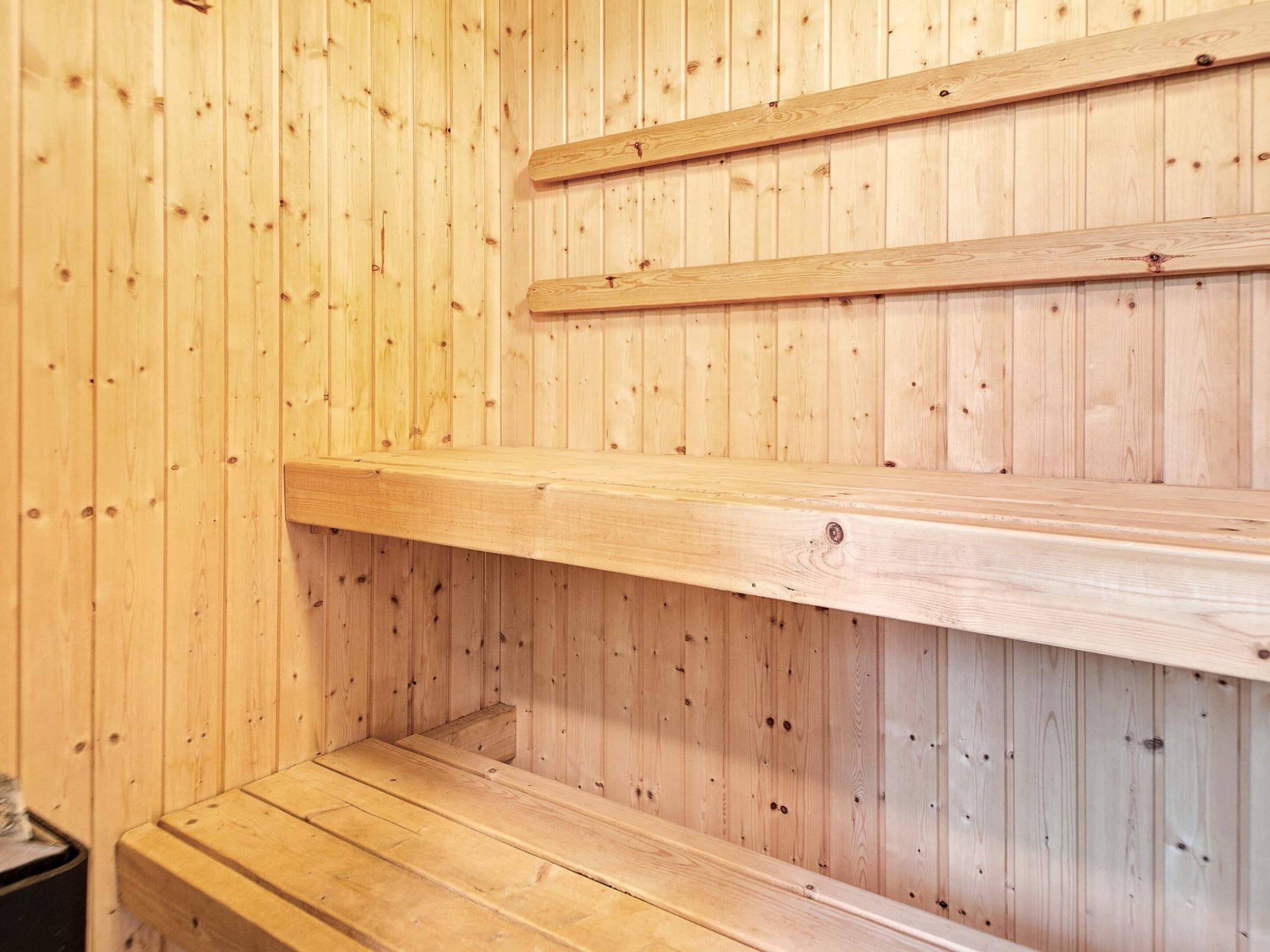 A wooden sauna with a bench and a shelf.