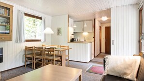 A compact living space with a dining area, a kitchenette, and a seating area with a couch. - 4 Star Holiday Home in Aakirkeby (Akirkeby)