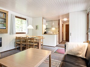 A compact living space with a dining area, a kitchenette, and a seating area with a couch. - 4 Star Holiday Home in Aakirkeby (Akirkeby)