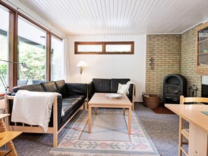 A cozy living room with a leather sofa, a wooden coffee table, and a fireplace.