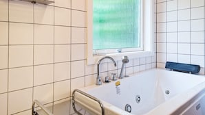 Une salle de bain moderne avec une baignoire, une fenêtre et une douche.