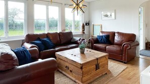 A living room with two brown leather sofas, a wooden coffee table, and a white cabinet. - 6 Person Holiday Home in Kopingsvik (Kopingsvik)
