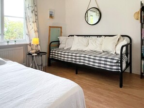 A room with a bed, a bedside table with a lamp, a mirror on the wall, and a bookshelf. - 6 Person Holiday Home in Kopingsvik (Kopingsvik)